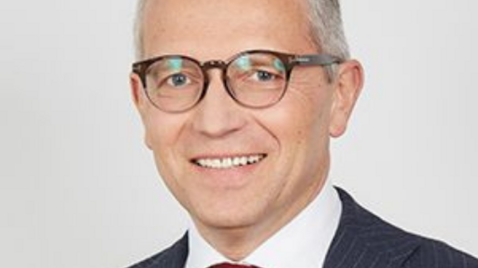 mężczyzna w garniturze i w okularach na jasnym tle