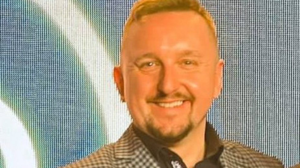 mężczyzna w kraciastym garniturze na niebieskim tle